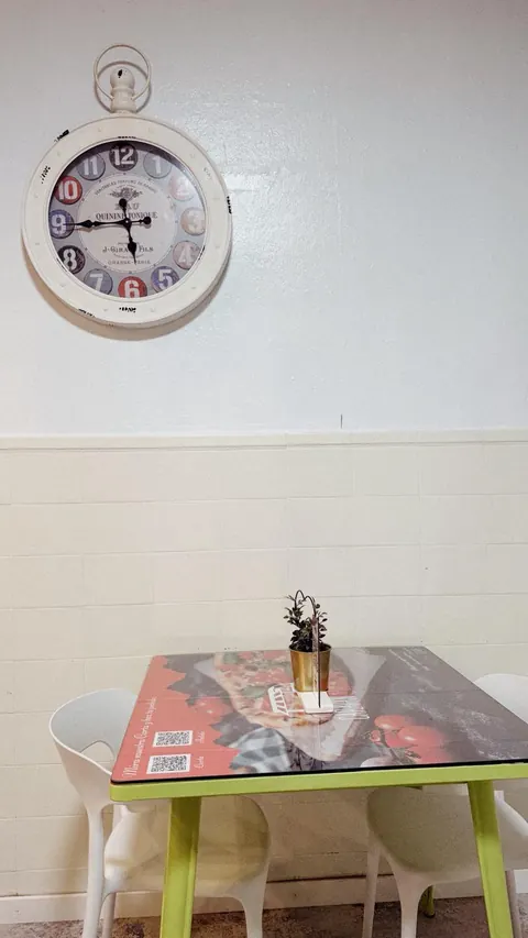 Mesa del local bajo un reloj de pared